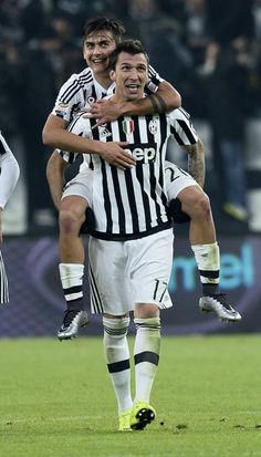 two soccer players are hugging each other on the field