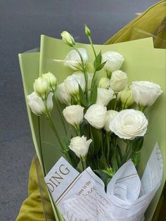 a bouquet of white flowers sitting on top of a green bag