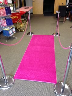 pink carpeted area with metal poles and barriers