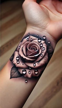 a woman's arm with a rose and water drops tattoo on the left wrist