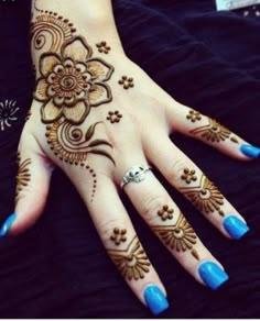 a woman's hand with henna tattoos on it