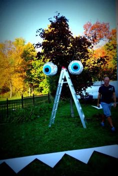 a man standing next to a ladder with eyes on it