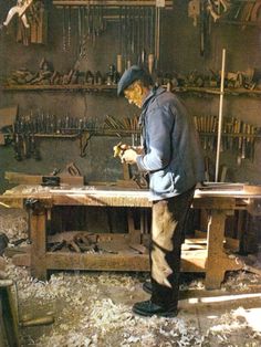 a man working in a shop with lots of tools