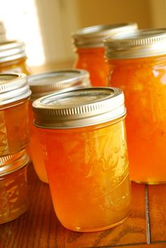 several jars filled with liquid sitting on top of a wooden table