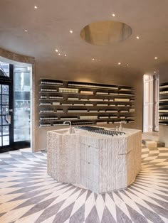 a room with many bottles on the wall and a circular table in front of it