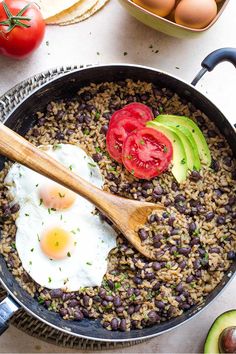 a skillet filled with beans, tomatoes and eggs