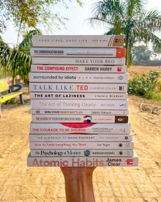 a person holding up a stack of books