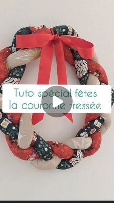 a christmas wreath with red ribbon hanging on the wall next to a sign that says, tuto special fetes la courre de tresse