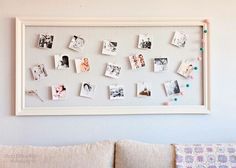 a white framed photo with pictures pinned to it