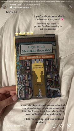 someone is holding up a book in their bed with the title days at the mohsaii bookshop