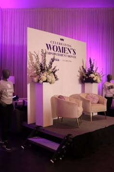 a stage set up for a women's conference with chairs and flowers on it