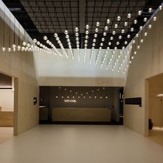 an empty room with lots of lights hanging from the ceiling and lighting on the walls