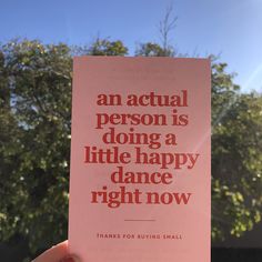 a person holding up a pink card that says, an actual person is doing a little happy dance right now