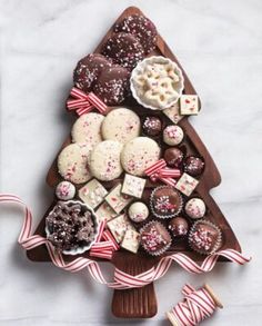 a christmas tree shaped platter filled with cookies and candies