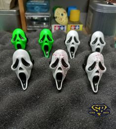 five plastic skulls with mouths open on a bed