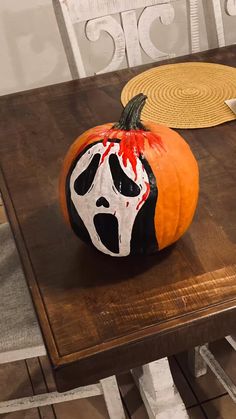 a painted pumpkin sitting on top of a wooden table