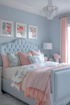 a bedroom with blue walls, pink and white bedding and pictures on the wall