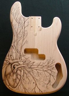 a wooden guitar with an image of the human heart on it's body and tree branches