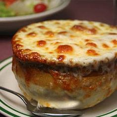 a close up of a pie on a plate with a fork and bowl in the background