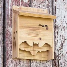 a wooden box with a bat on it hanging from the side of a wood wall