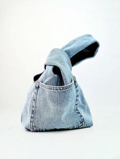 a pair of blue jeans are folded up in the shape of a purse with a hole in it