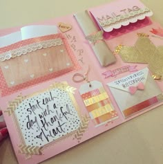 the inside of a pink scrapbook with lots of different items on top of it