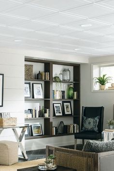 a living room filled with furniture and bookshelves next to a wall mounted book shelf