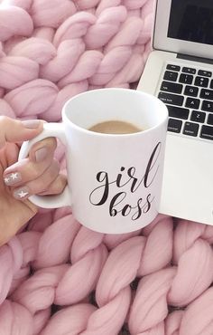 a woman's hand holding a coffee mug with the word girl boss on it