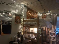 a loft bed with lights strung from the ceiling and curtains on the wall above it