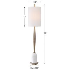 the floor lamp has a white shade on it and is next to a tall metal pole with