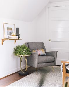 a living room with a chair, table and potted plant