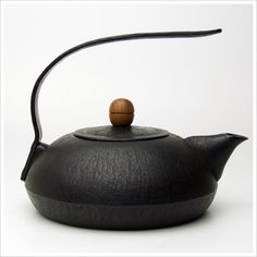 a black tea pot with a wooden handle