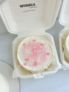 a birthday cake in a white box with pink frosting