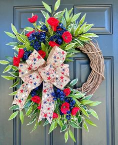 a patriotic wreath with red, white and blue flowers on the front door for memorial day