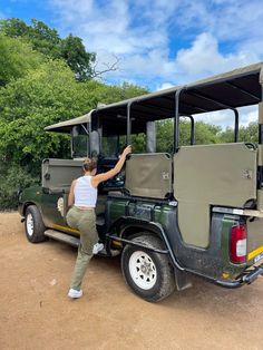 a woman standing next to a safari vehicle