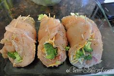 four pieces of raw fish with broccoli and cheese on them sitting on a glass plate