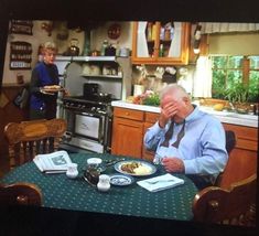 an old man sitting at a table with food in front of him