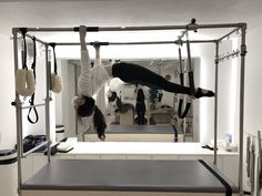 a woman is doing aerial acrobatic exercises in a room with other people