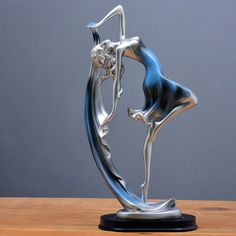 a silver and blue figurine sitting on top of a wooden table