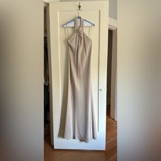 a dress hanging on a hanger in front of a door