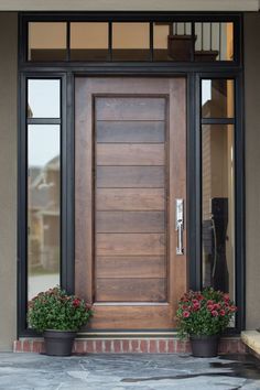 a wooden door with two planters on the side