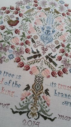 a cross stitch pattern with flowers and birds on it