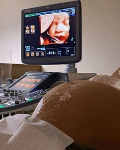 a computer monitor sitting on top of a table next to a bag and remote control