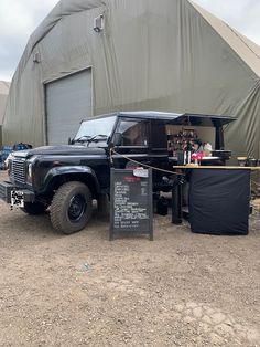 an army truck parked in front of a tent