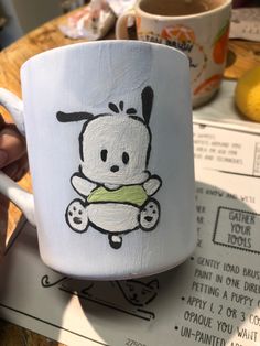 a person holding a coffee cup with a drawing on it