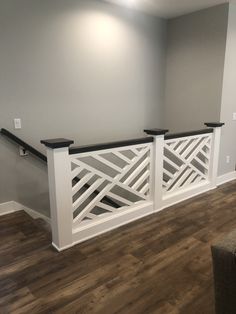 an empty room with wood flooring and white railings on the wall above it