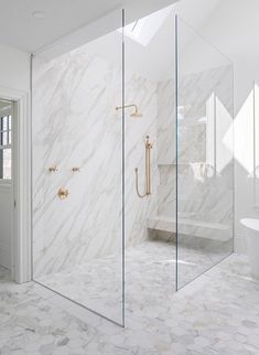 a white bathroom with marble walls and floors