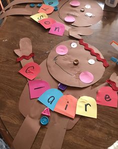 paper plates with cut out letters on top of a wooden table