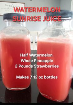 two jars filled with watermelon juice on top of a table