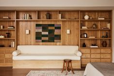 a living room filled with furniture and bookshelves next to a white couch on top of a hard wood floor